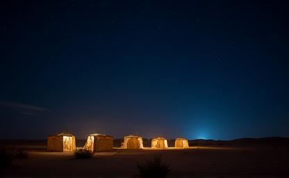 Traditional desert camp illuminated under a starry night sky